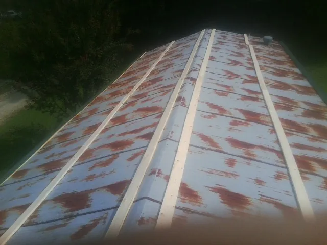 Rusted metal roof panels with new wood purlins before replacement — Storm Damage Roof Repair in Mc Leansville by Roofing Brothers