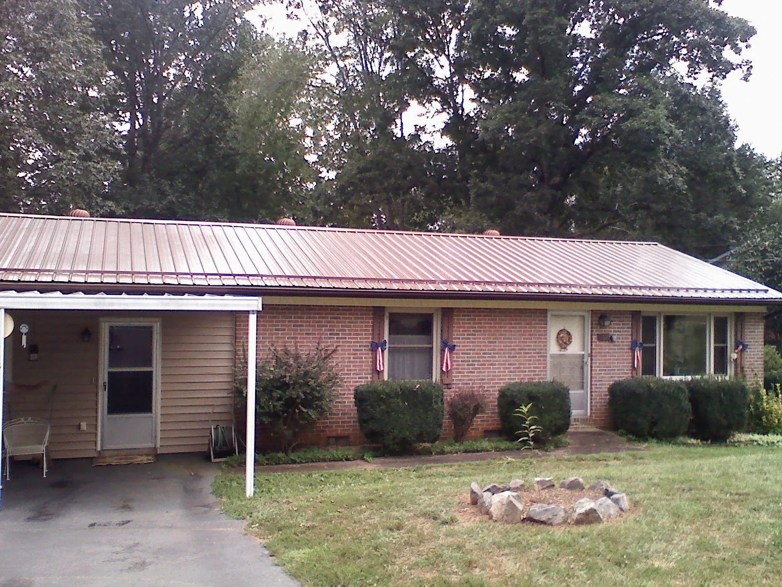 Bronze metal roof and carport on a brick ranch home — Roof Repair work by our crew in Mc Leansville